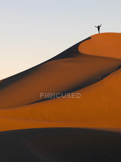 Person steht tagsüber auf einem Bergrücken des Sandhangs im Freien — Stockfoto