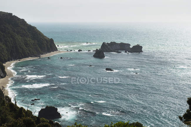 Sandy beach on base of cliff — Stock Photo