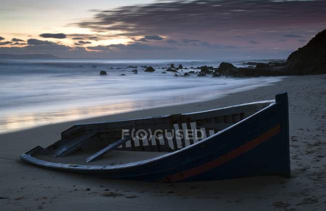 Barco abandonado en la playa - foto de stock