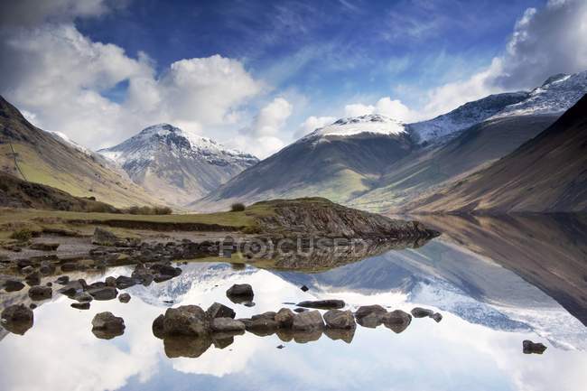 Montañas y lago con piedras - foto de stock