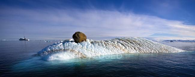 Iceberg en el agua con barco - foto de stock