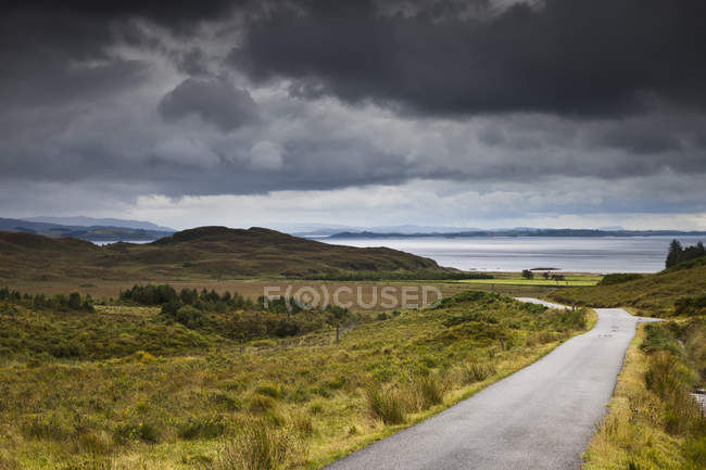 Eine Landstraße durch eine hügelige Landschaft entlang der Küste; — Stockfoto