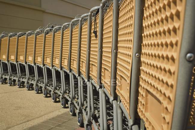 Lote de carrinhos de compras colocados em filas no estacionamento — Fotografia de Stock
