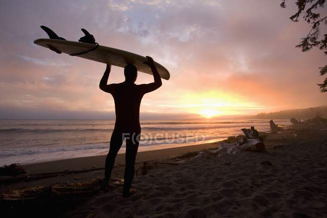 Uomo che trasporta tavola da surf — Foto stock