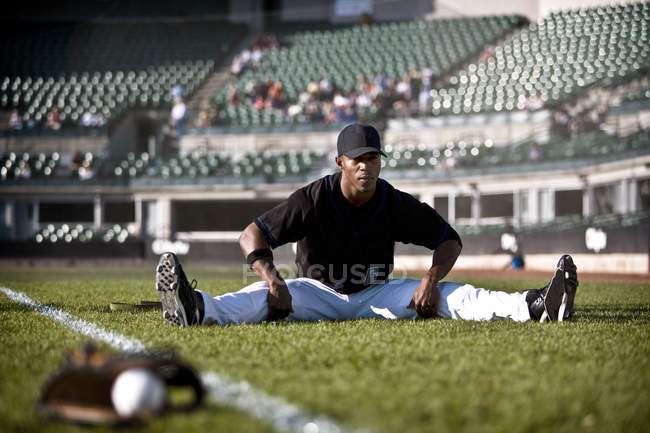 Vue du joueur de baseball s'étirant sur le terrain — Photo de stock