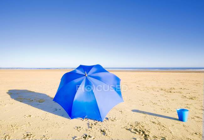 Parapluie et seau sur la plage — Photo de stock