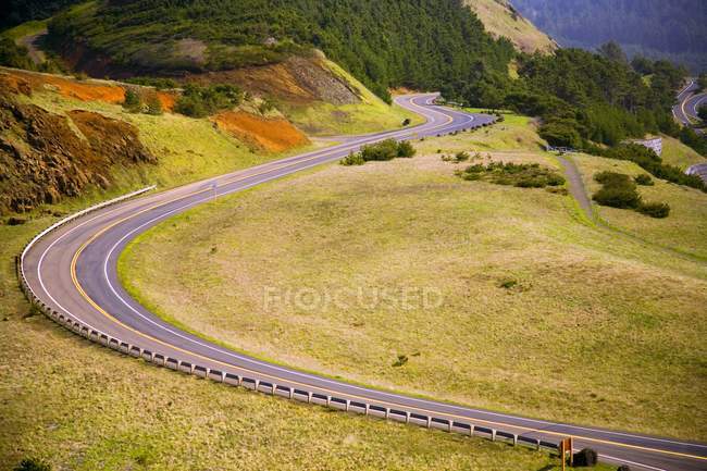 Carretera rural sobre campos verdes - foto de stock