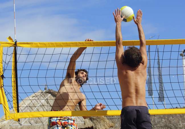 Двое мужчин играют в пляжный волейбол — стоковое фото