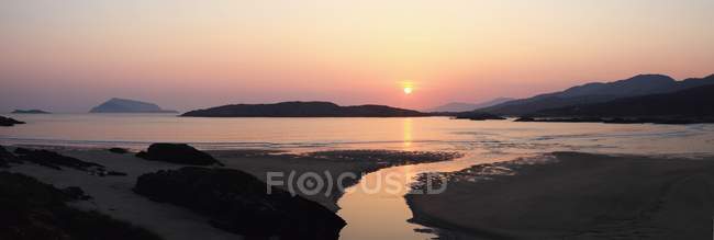 Захід сонця над пляжем з та — стокове фото