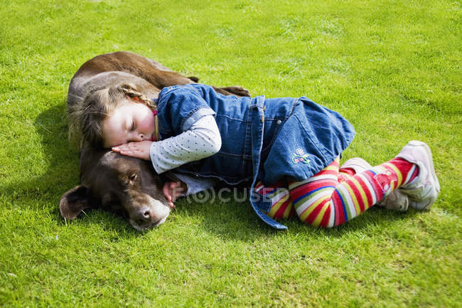 Маленька дівчинка спить на собаці — стокове фото