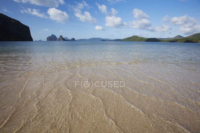 Aguas poco profundas y arena en una isla cerca de El Nido - foto de stock