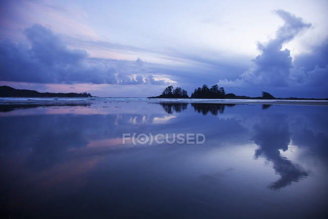 Clouds Over beach with trees — Stock Photo