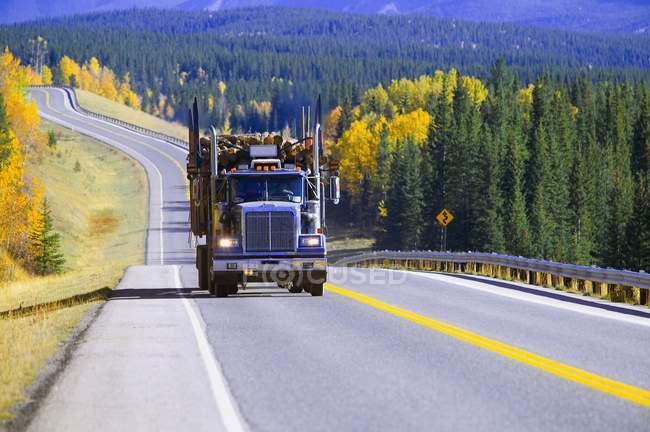 Camion d'exploitation forestière dans la route vide. Alberta, Canada — Photo de stock