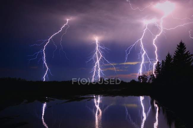 Буря блискавки над озером — стокове фото