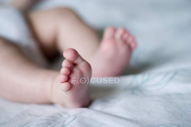 Recortado vista de cerca de pies de bebé desnudos - foto de stock