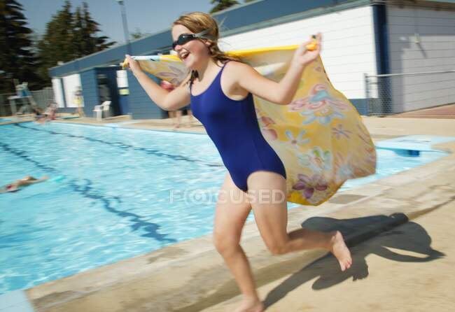Criança feliz correndo por uma piscina — Fotografia de Stock