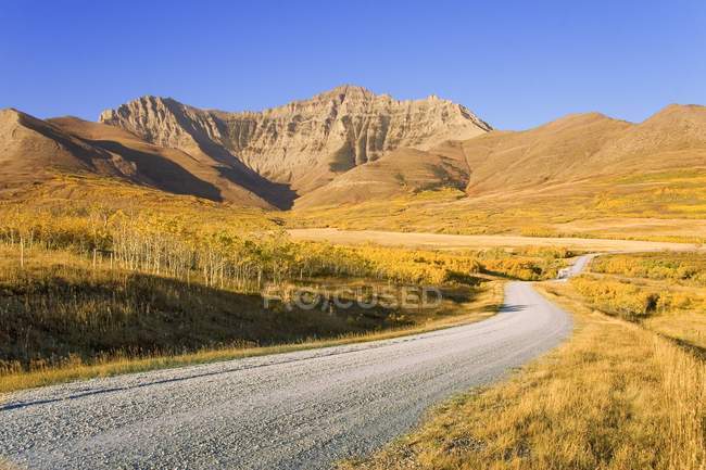 Strada in autunno attraverso le montagne — Foto stock