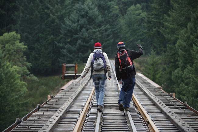 Caminantes caminando sobre raíles en la Columbia Británica - foto de stock