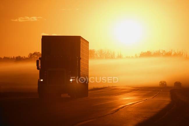 Nascer do sol na estrada com carro — Fotografia de Stock