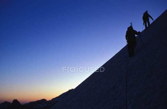 Альпинисты карабкаются по склону — стоковое фото
