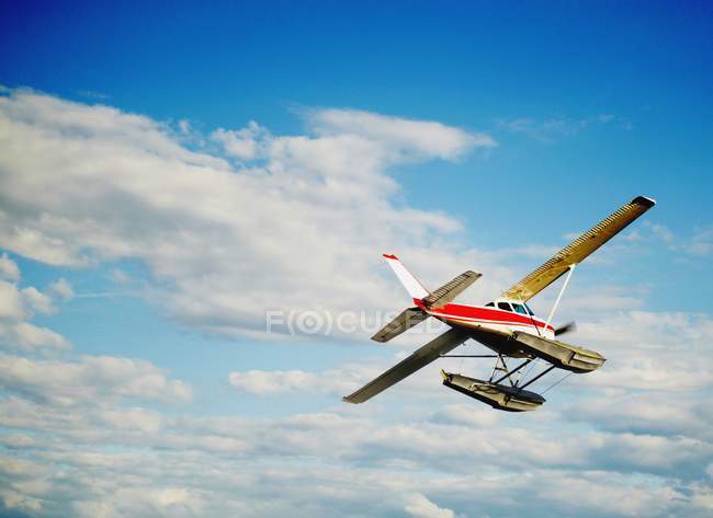 Um avião no céu contra as nuvens — Fotografia de Stock