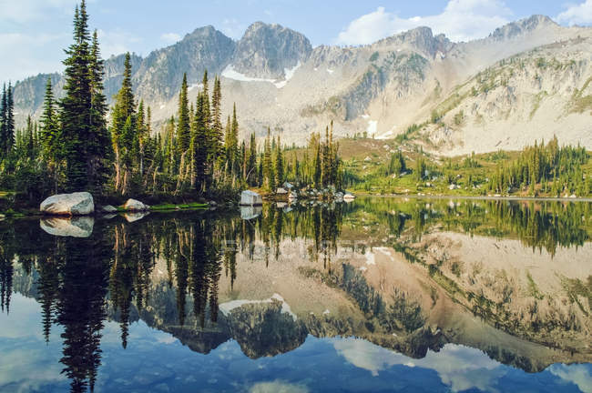 Spiegelungen von Bäumen und Bergen im blauen See — Stockfoto