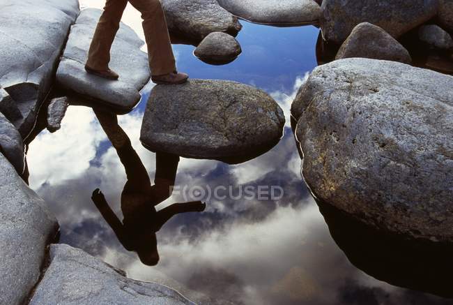 Reflection Of hiker Crossing  Stream — Stock Photo