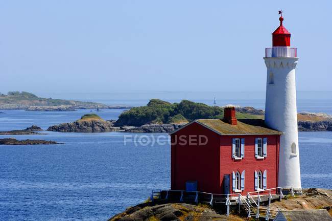 Lighthouse with small red house — Stock Photo