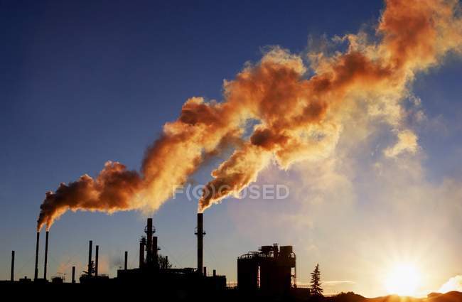 Refinery with smoke from towers — Stock Photo