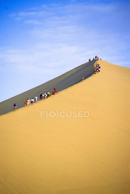 Gente en la duna de arena - foto de stock