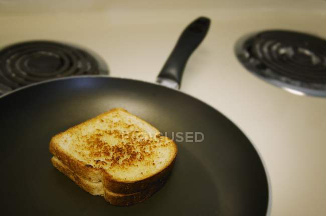 Смажений бутерброд на сковороді над плитою — стокове фото