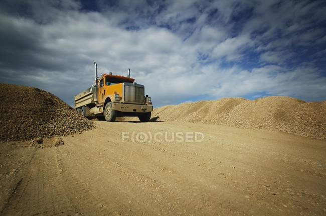 Caminhão de cascalho na estrada de terra — Fotografia de Stock