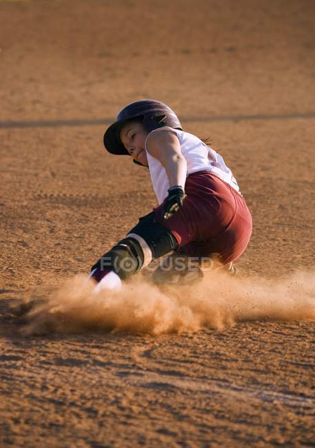 Jovem jogadora de beisebol deslizante feminina — Fotografia de Stock