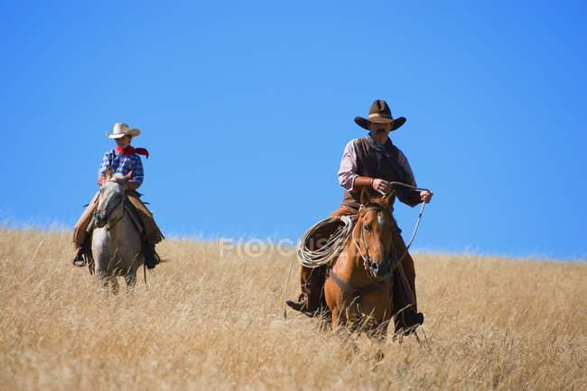 Dos vaqueros con sombreros - foto de stock