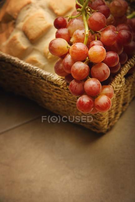 Uvas y pan en cesta - foto de stock