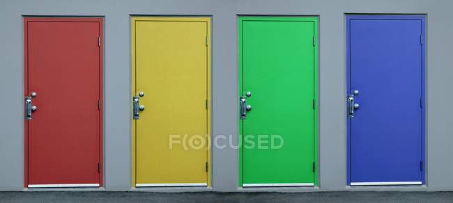 Conjunto de portas coloridas na parede cinza — Fotografia de Stock