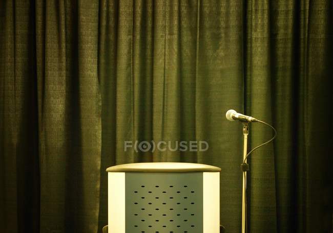 Рострум і мікрофон стоять на фоні зелених штор — стокове фото