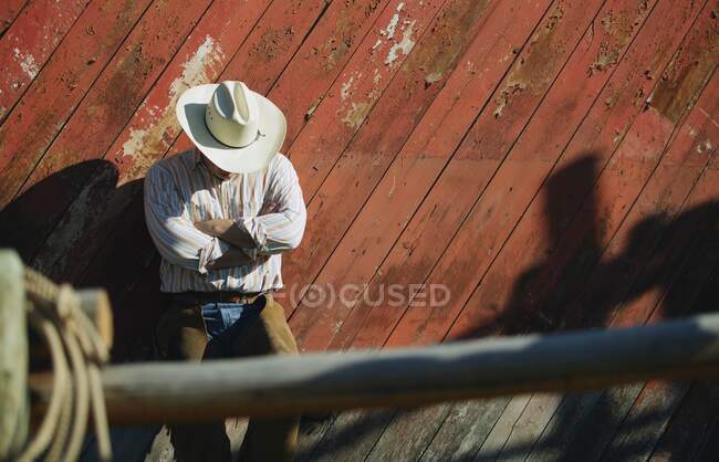 Cowboy mit Hut lehnt an hölzerner Mauer — Stockfoto