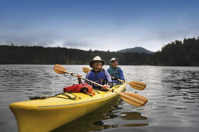 Feliz medio adulto caucásico pareja kayak en río - foto de stock