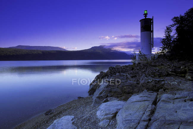 Faro e lago all'alba — Foto stock