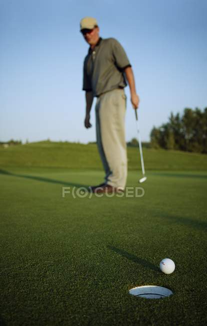 Blanc mi-adulte golfeur manqué le trou — Photo de stock