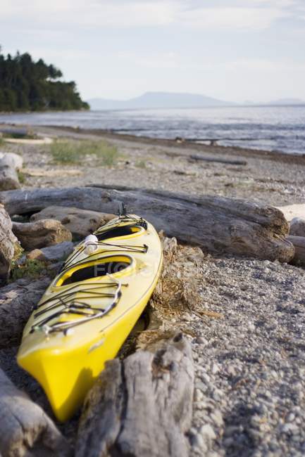 Kayak amarillo en la playa - foto de stock