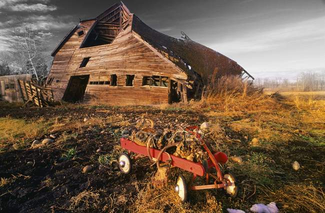 Ancienne grange avec chariot rouge — Photo de stock