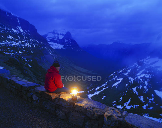 Hombre sentado en las rocas - foto de stock