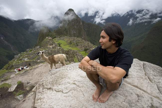 Hombre y alpaca en ruinas antiguas - foto de stock