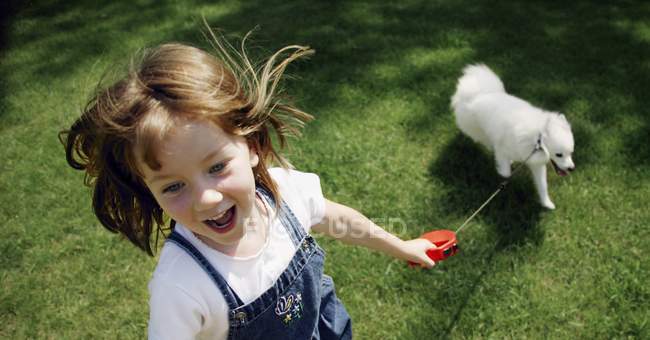 Petite fille jouant avec le chien — Photo de stock