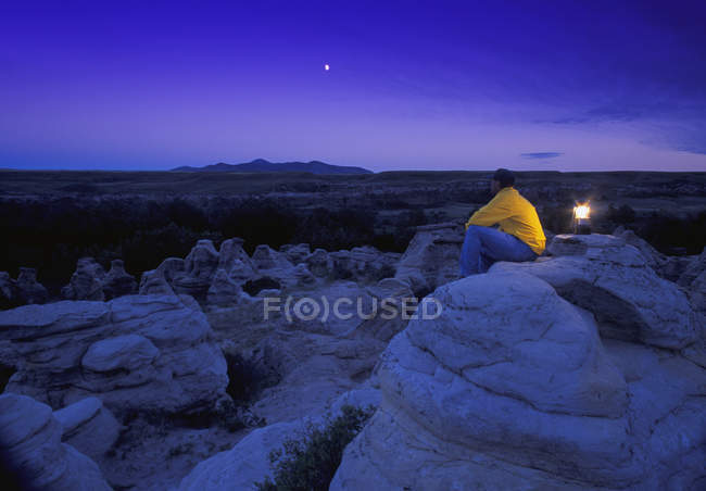 Hombre sentado en las rocas - foto de stock
