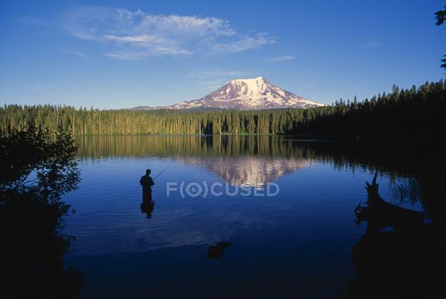 Fisherman stands in water — Stock Photo