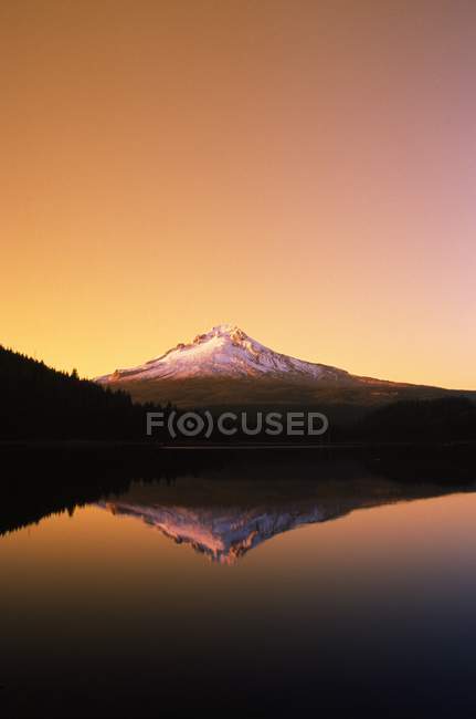 Puesta de sol en el lago con montaña - foto de stock