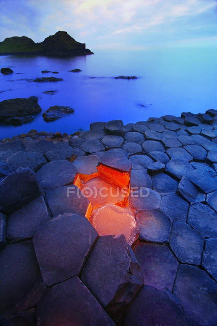 Pico de pedras contra a água — Fotografia de Stock
